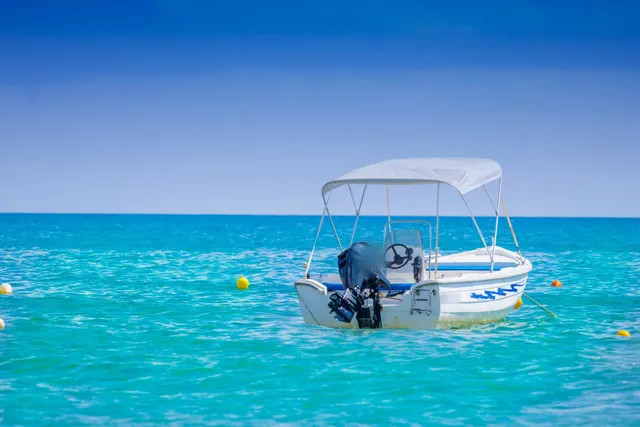 Turkuaz denizde bimini tenteli küçük tekne